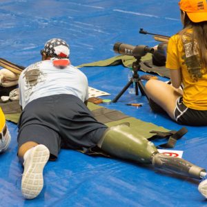 man with amputation lying prone aiming in air rifle