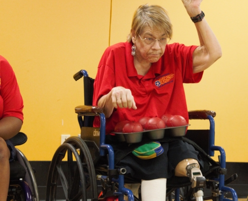 woman in wheelchair preparing to throw bocca ball