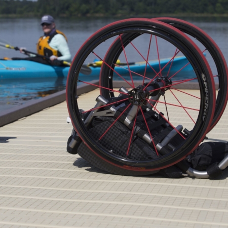 picture of Ashley in Kayak in background with an empty wheelchair in the foreground