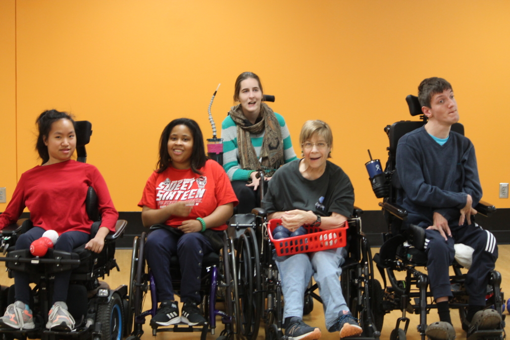 Five Bridge 2 Sports Boccia athletes using wheelchairs pose as a team with Karen Stallings in middle