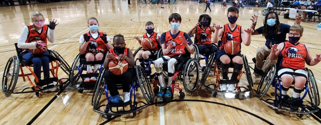 Bridge 2 Sports Team PRIDE varisty youth wheelchair basketball players pose as team with 'paws up' all in sport wheelchairs at tournament